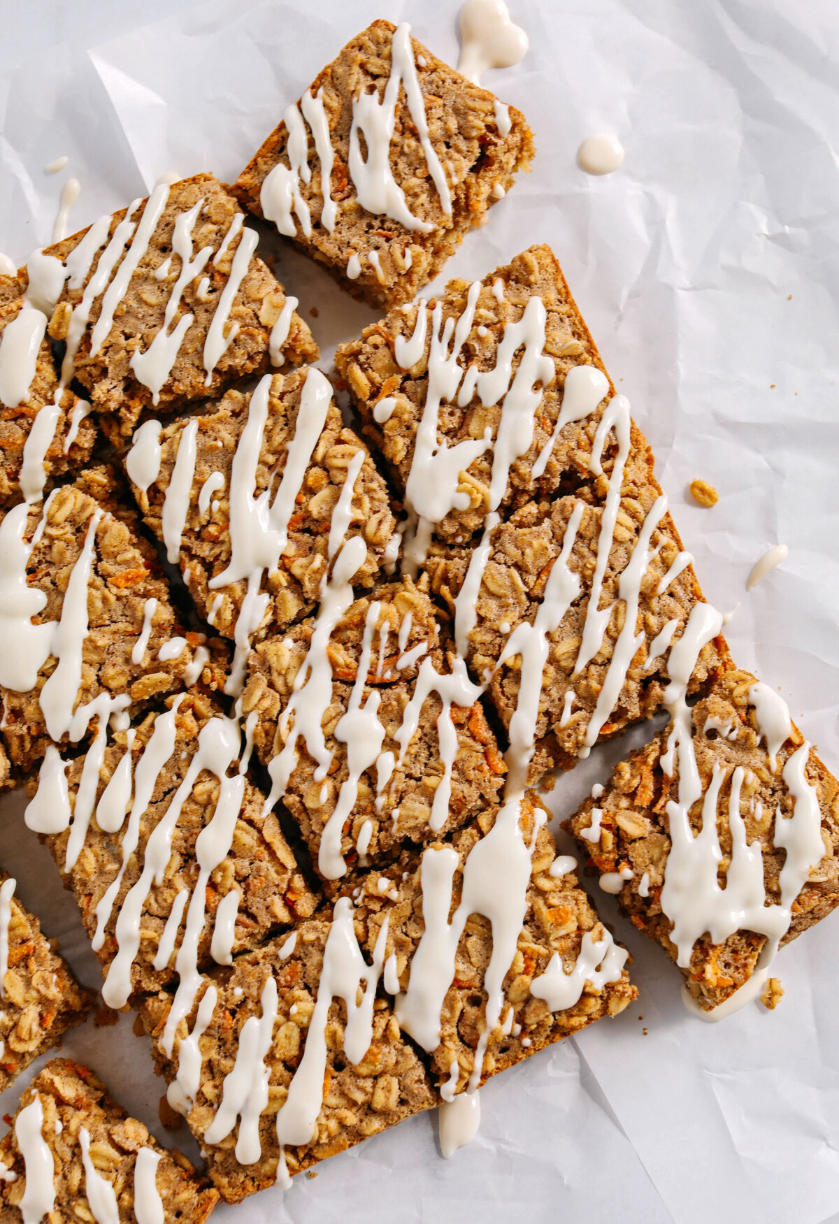 These EASY Carrot Cake Oatmeal Breakfast Bars make a quick on-the-go breakfast, snack or healthy dessert made with zero refined sugar and drizzled with a delicious maple cream cheese frosting! 