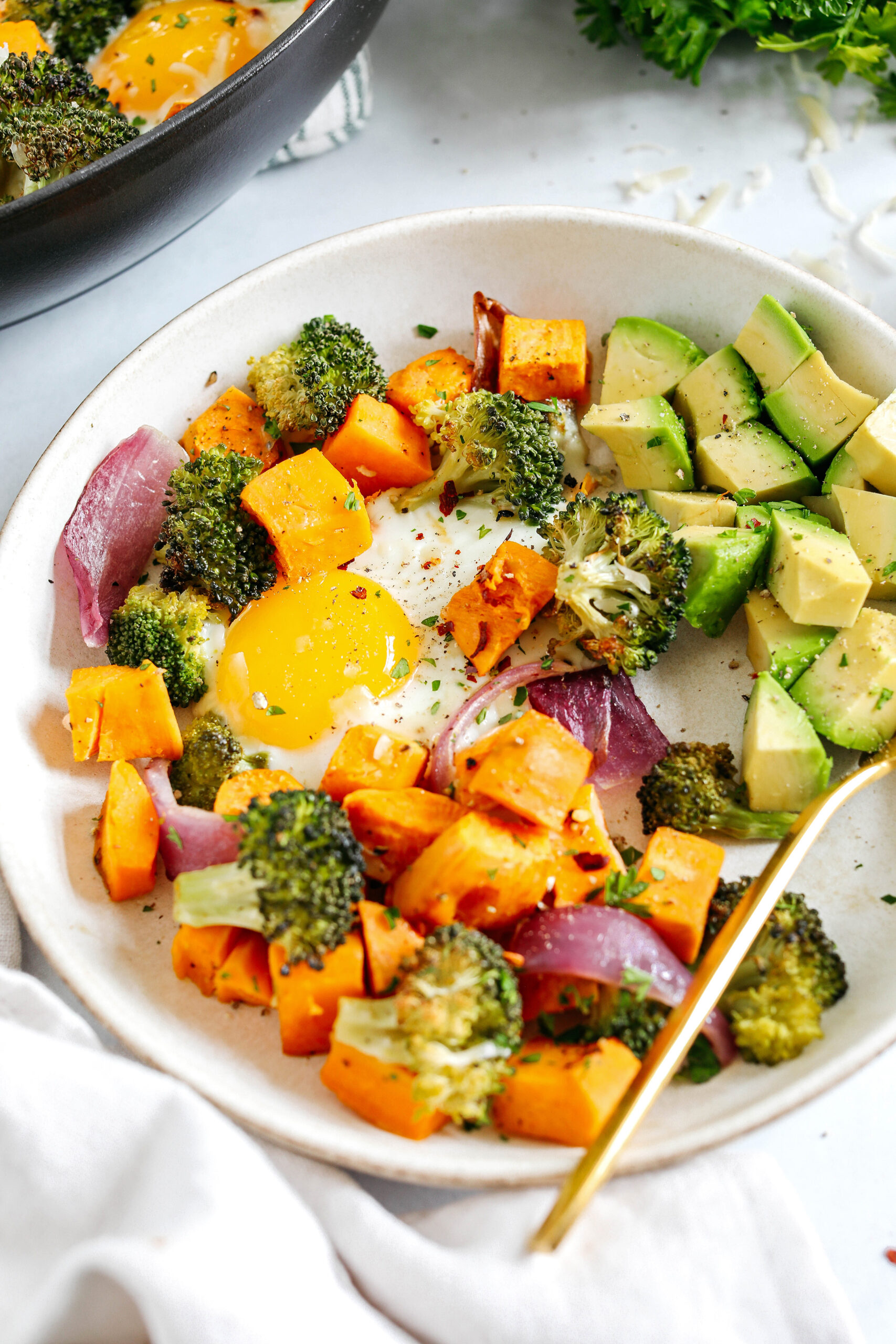 Roasted Veggie Breakfast Skillet made all in one pan with a hearty combination of sweet potatoes, broccoli and red onion topped with baked eggs and seasoned to perfection for a healthy delicious breakfast or dinner!