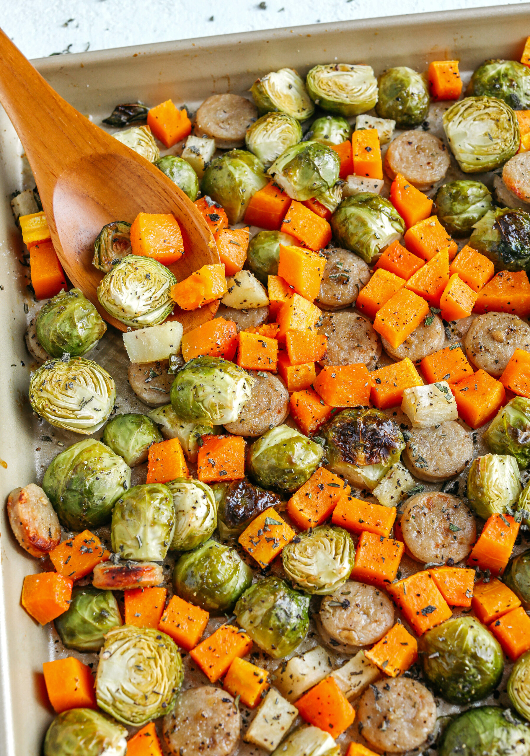 Harvest Sheet Pan Sausage and Veggies loaded with flavorful chicken sausage, butternut squash, brussels sprouts, and apples for a quick and easy dinner made in just 30 minutes!  Roasted in a maple mustard glaze and fresh herbs for the perfect fall meal!  