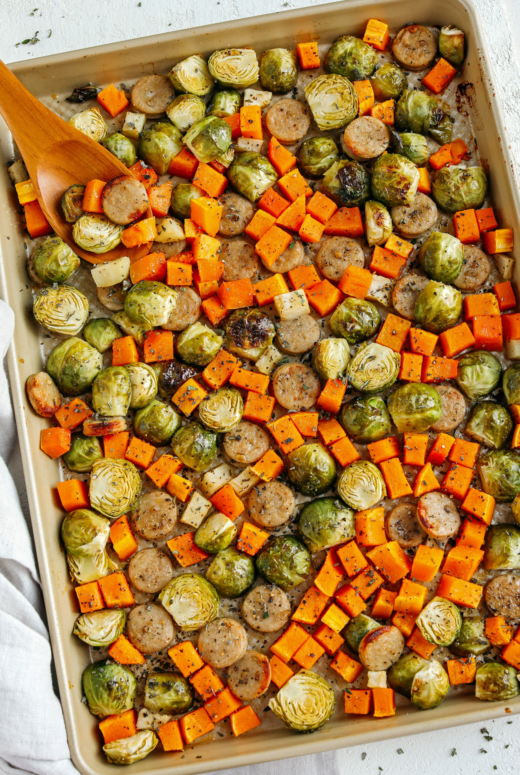 Harvest Sheet Pan Sausage and Veggies loaded with flavorful chicken sausage, butternut squash, brussels sprouts, and apples for a quick and easy dinner made in just 30 minutes!  Roasted in a maple mustard glaze and fresh herbs for the perfect fall meal!  