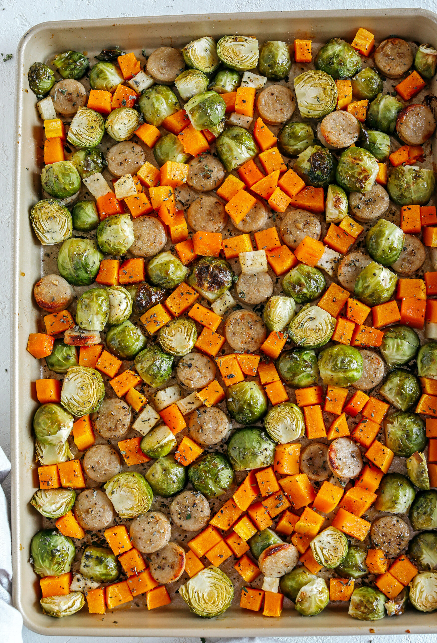 Harvest Sheet Pan Sausage and Veggies loaded with flavorful chicken sausage, butternut squash, brussels sprouts, and apples for a quick and easy dinner made in just 30 minutes!  Roasted in a maple mustard glaze and fresh herbs for the perfect fall meal!  