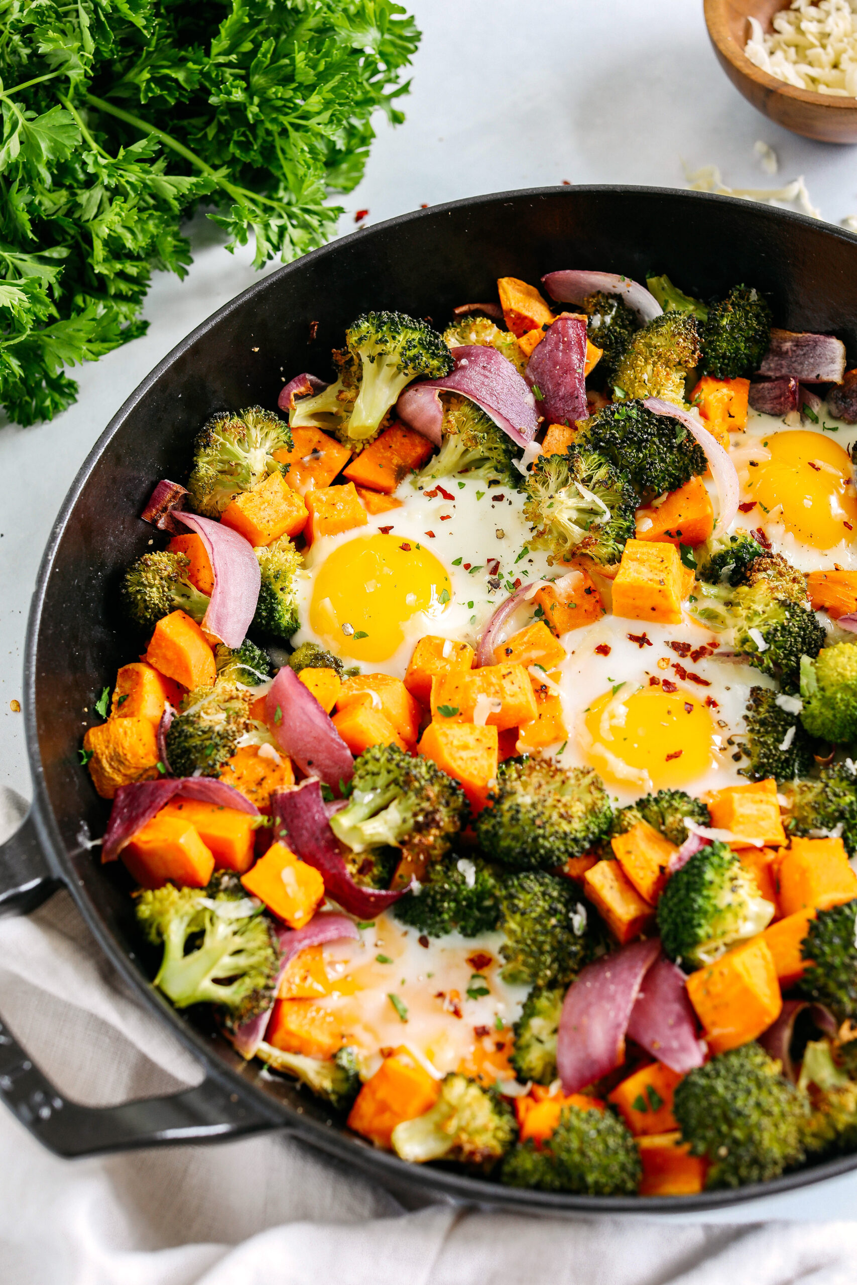 Roasted Veggie Breakfast Skillet made all in one pan with a hearty combination of sweet potatoes, broccoli and red onion topped with baked eggs and seasoned to perfection for a healthy delicious breakfast or dinner!